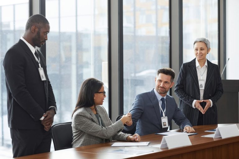 Starting a Business in Guinea Step-by-Step Guide for Foreign Investors - YES! INVEST in GUINEA A group of diverse entrepreneurs shaking hands in a modern Conakry office, representing the collaborative spirit of Yes! Invest in Guinea.